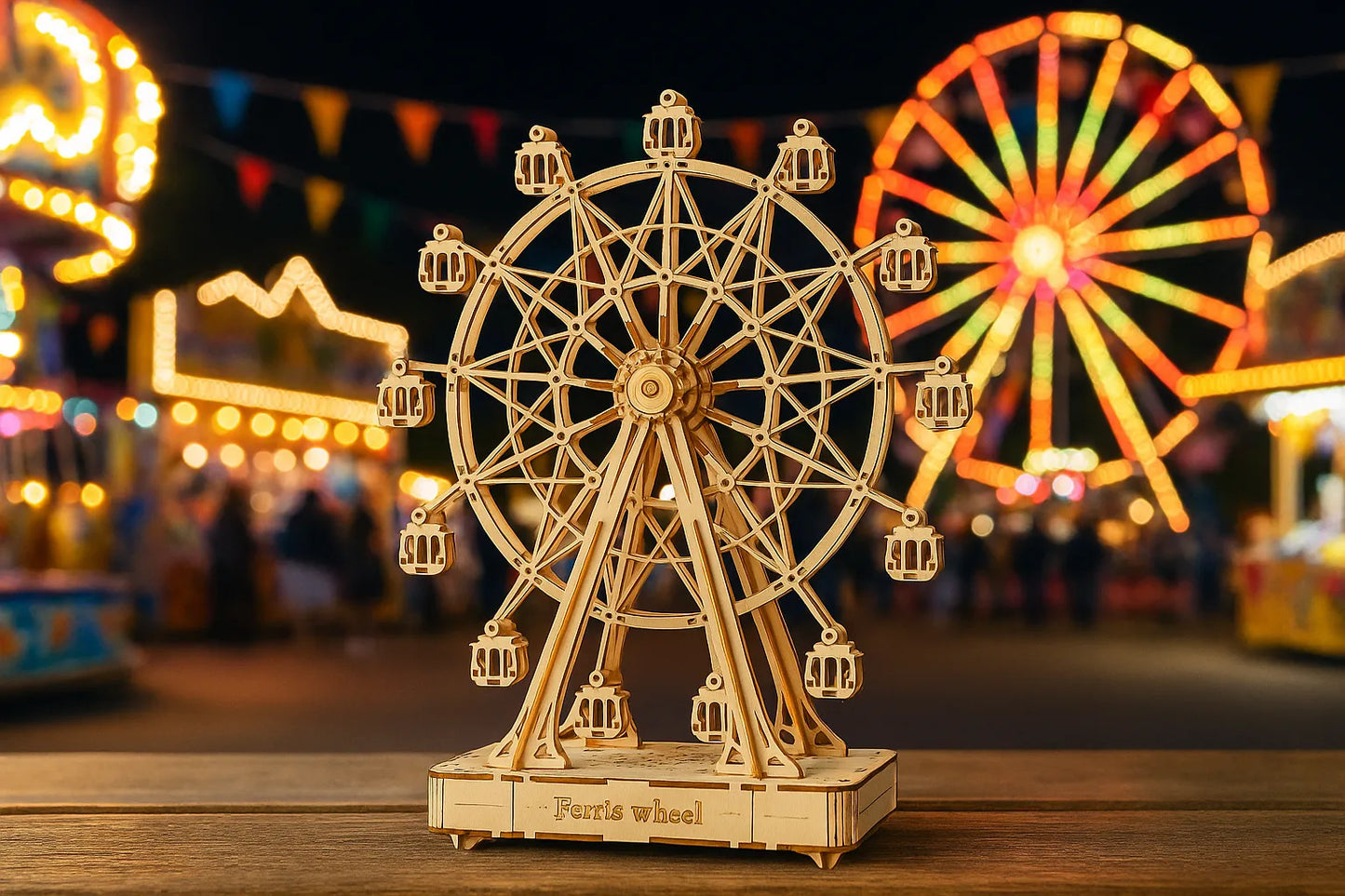 Maquette en bois d’une grande roue posée sur une table en bois avec une fête foraine lumineuse en arrière-plan.