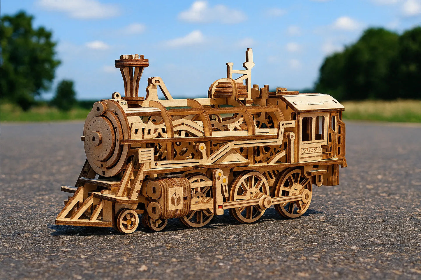 Maquette en bois dâune locomotive classique dĂ©taillĂ©e posĂ©e sur une route avec un ciel bleu.