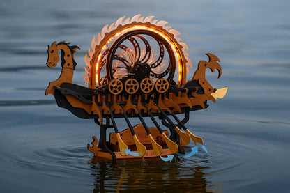Maquette en bois d’un drakkar mécanique lumineux flottant sur la mer au crépuscule.
