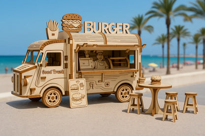 Maquette en bois d’un food truck en forme de camion de burgers avec tables et tabourets, placée sur une promenade en bord de mer bordée de palmiers.