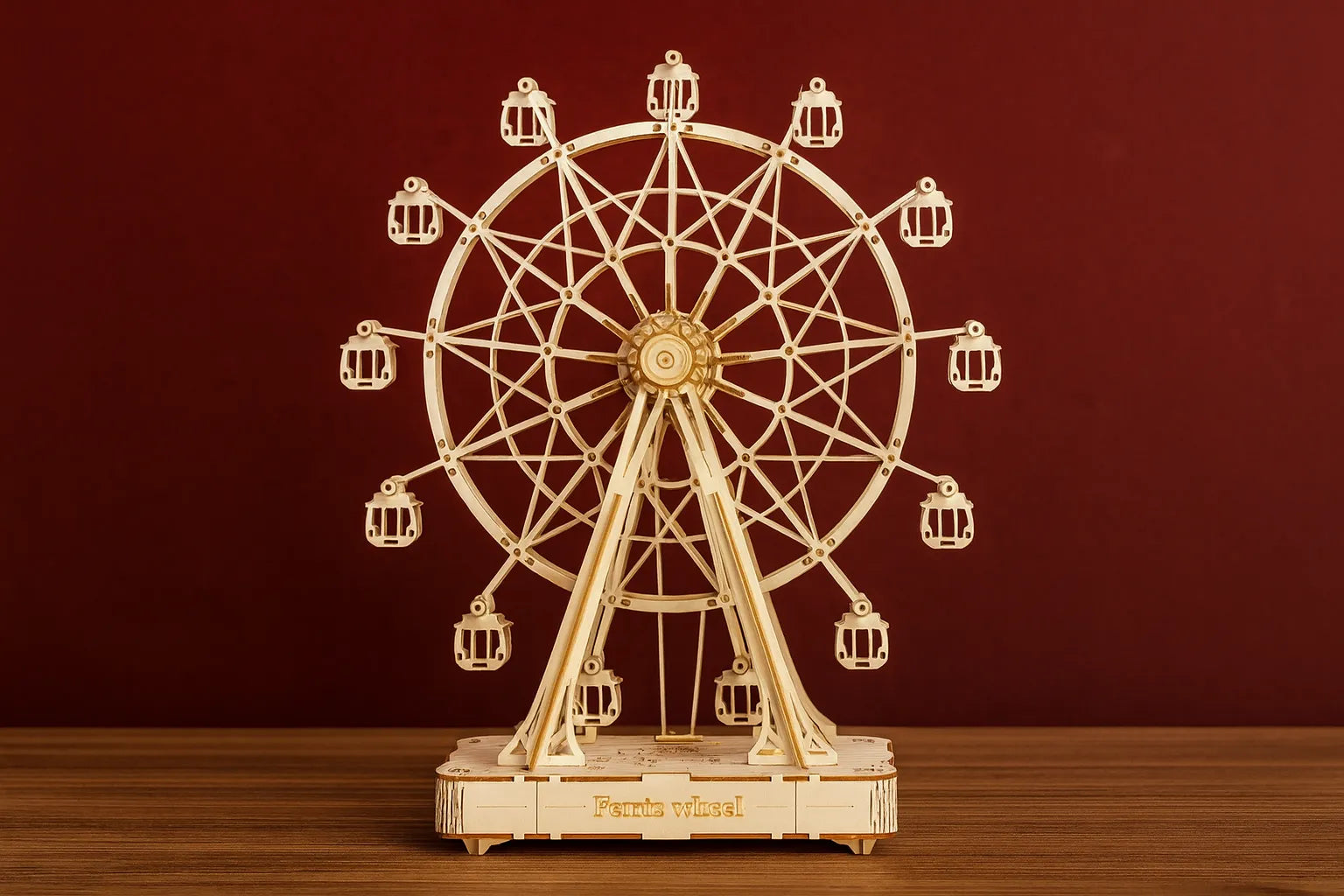 Maquette en bois d’une grande roue posée sur une table en bois devant un mur rouge.