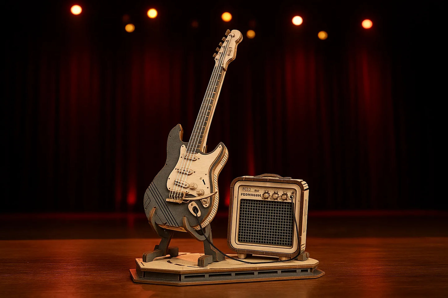 Maquette en bois d’une guitare électrique noire et beige avec amplificateur rétro, mise en valeur sur une scène de concert aux projecteurs chauds.