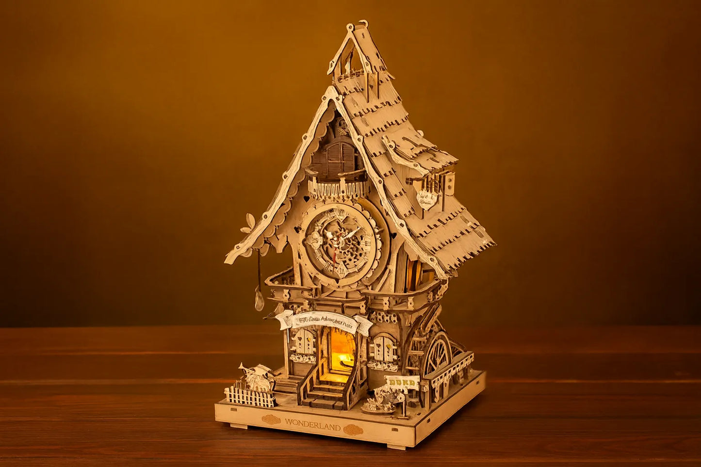 Maquette en bois d’une maison horloge avec un toit en pente posée sur une table en bois avec un fond jaune.