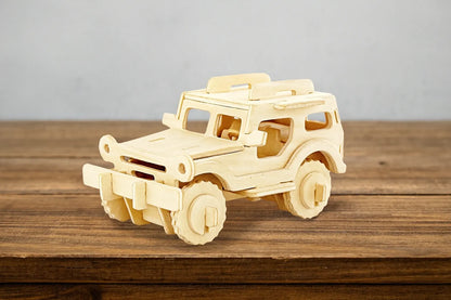 Maquette en bois d’une jeep tout-terrain beige, posée sur une table en bois devant un mur gris clair.