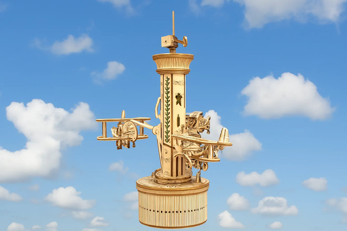 Maquette en bois d’un manège aérien avec de petits avions fixés autour d’une tour, sur fond de ciel bleu et de nuages.