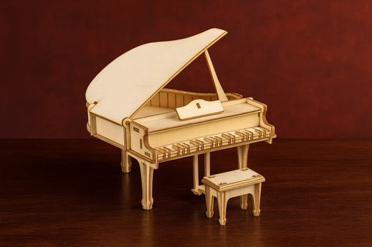 Maquette en bois d’un piano à queue et de son tabouret assorti, posée sur une table en bois devant un fond rouge.