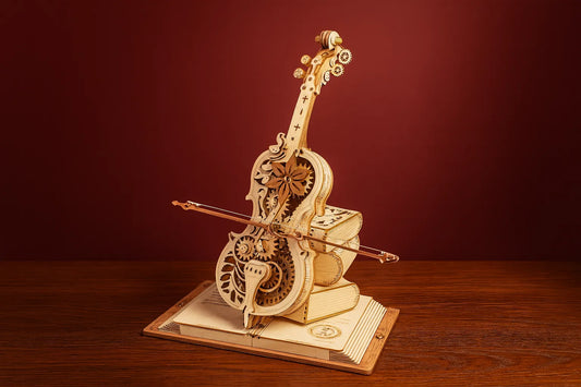 Maquette en bois d’un violon fleuri, au design mécanique et poétique, monté sur une base en forme de livres anciens, devant un fond rouge chaleureux et posé sur une table en bois.