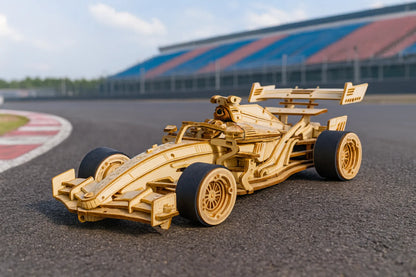Maquette en bois d’une voiture de Formule 1 avec pneus noirs, posée sur une piste de circuit entourée de gradins colorés.
