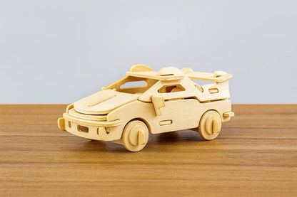 Maquette en bois d’une voiture de sport stylisée, couleur bois clair, placée sur une table en bois devant un mur gris clair.